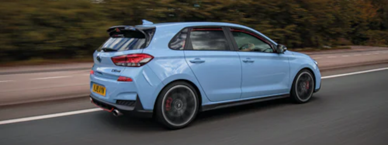 blue car travelling along the road