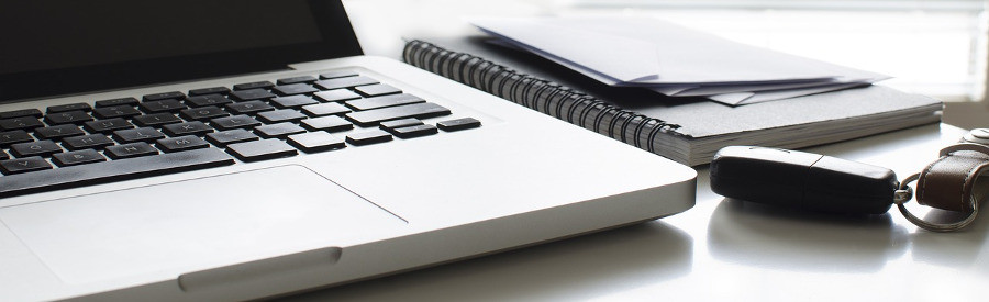 laptop, papers and car keys creating a car hire checklist