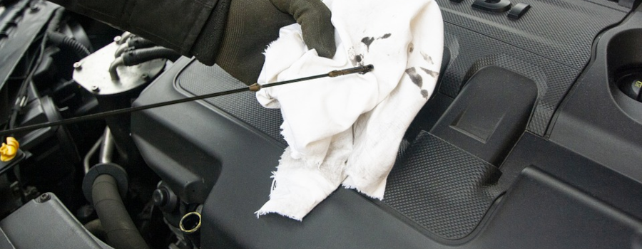 man checking car oil levels