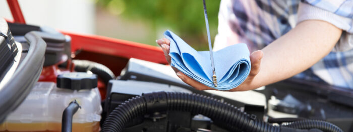man checking the oil level in his car