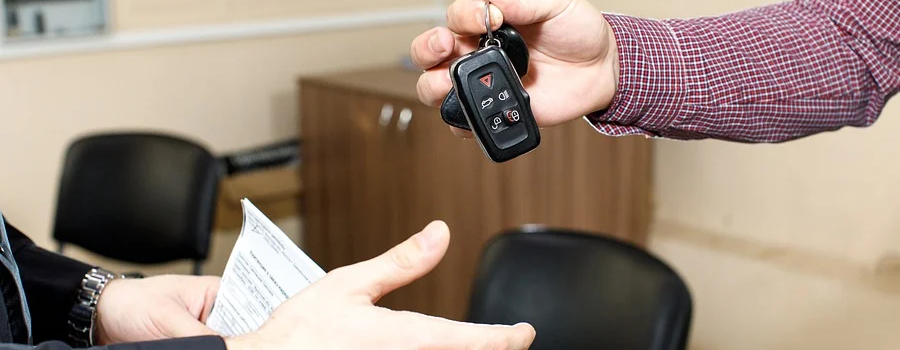 man handing over car keys