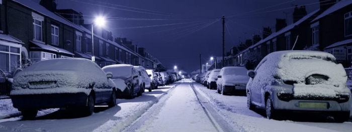 snow covered street with parked cars
