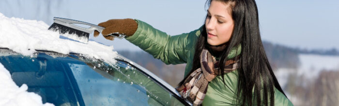 woman clearing snow off her car