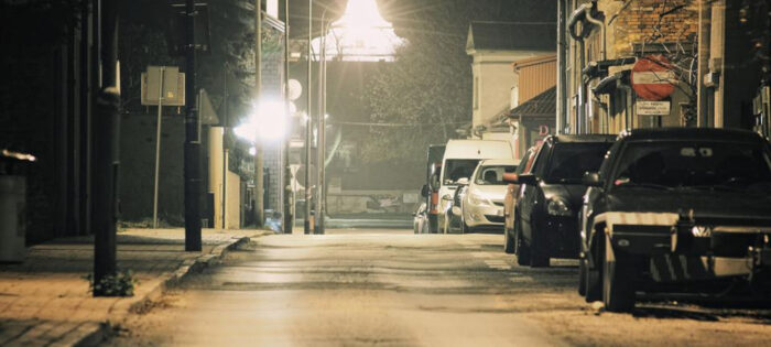 dark street with parked vehicles