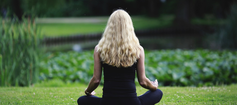 Woman sitting on grass meditating
