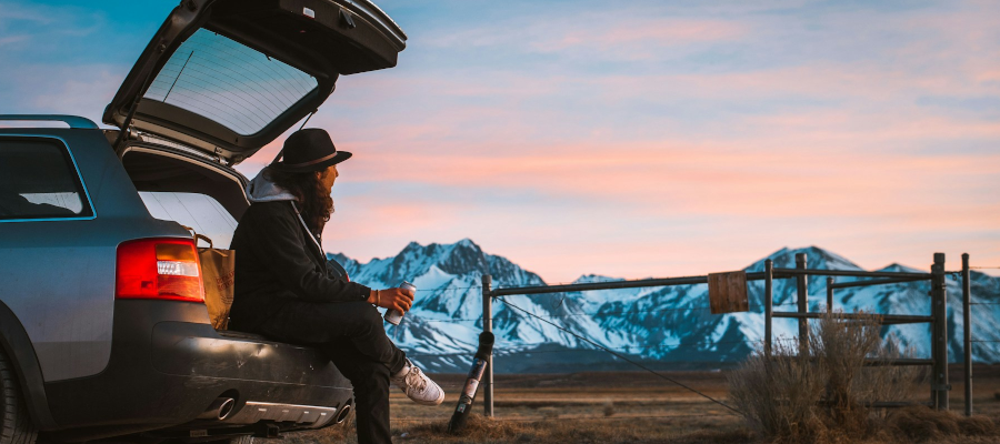 Man sitting in the boot of his car while car camping
