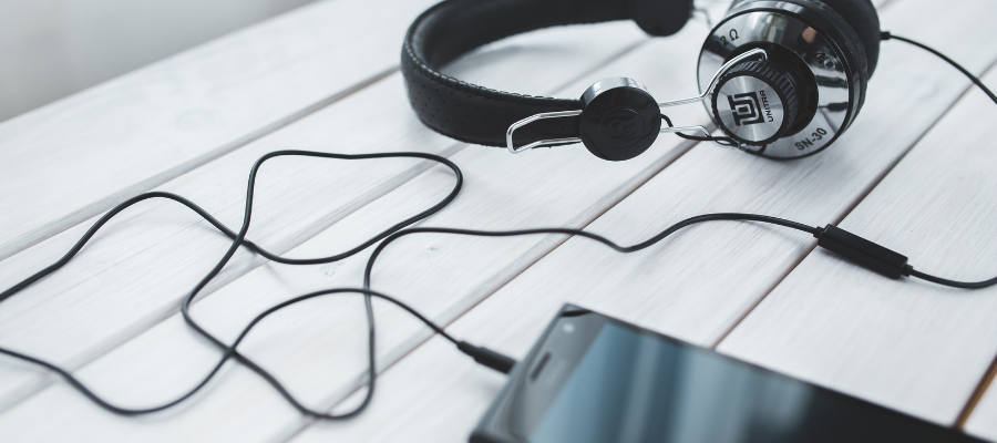 Headphones connected to phone listening to audiobook