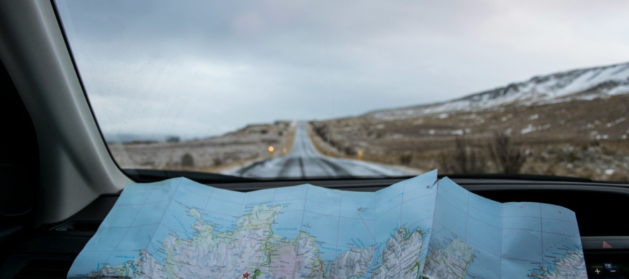 Car driving on winter roads with paper road map