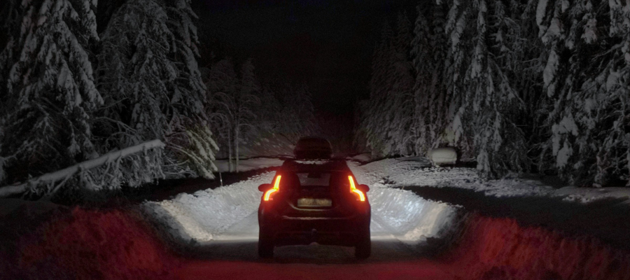 Car driving on a country road at night with their car lights on